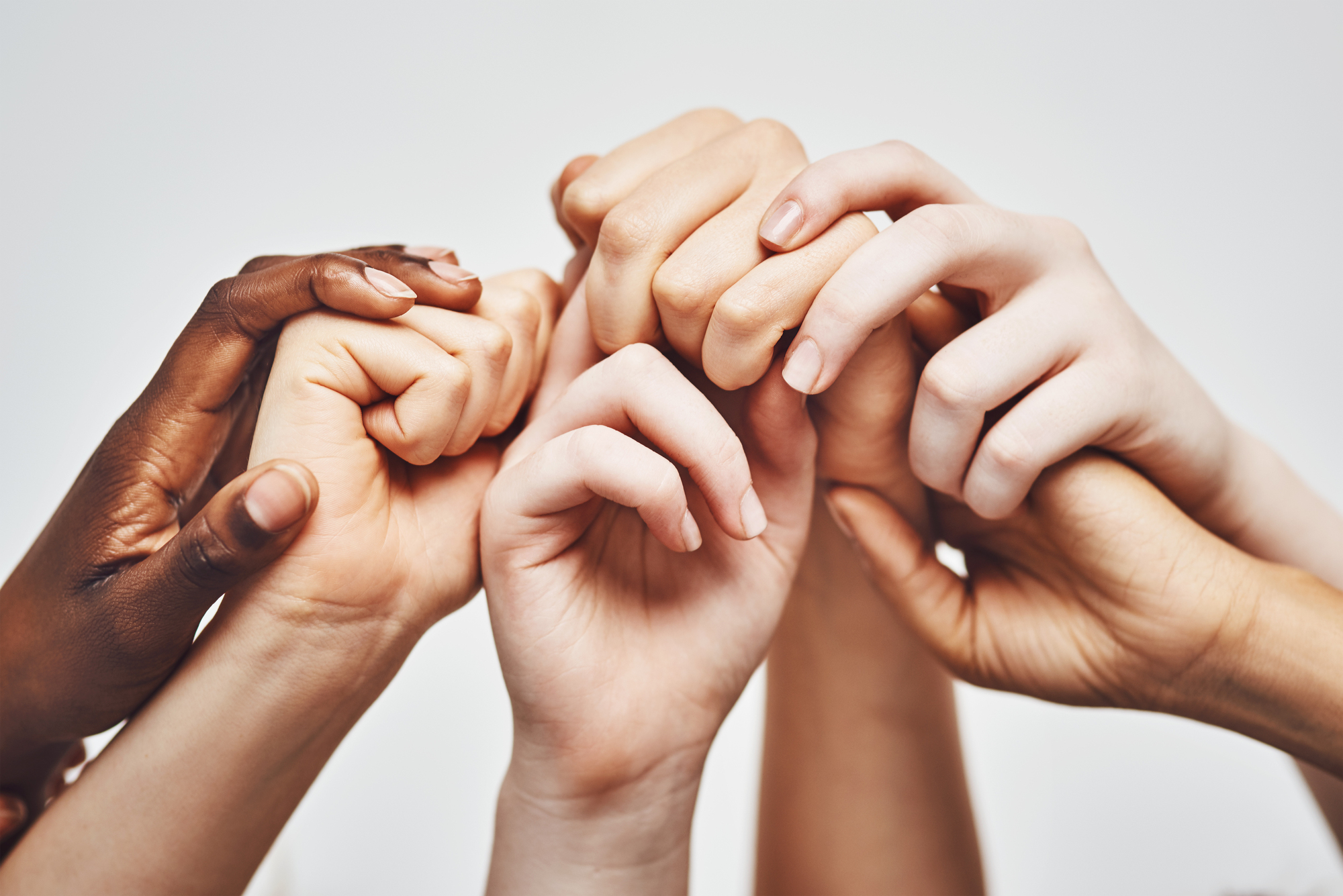 Hold on to whatever makes you stronger. a group of hands holding onto each other against a white background.